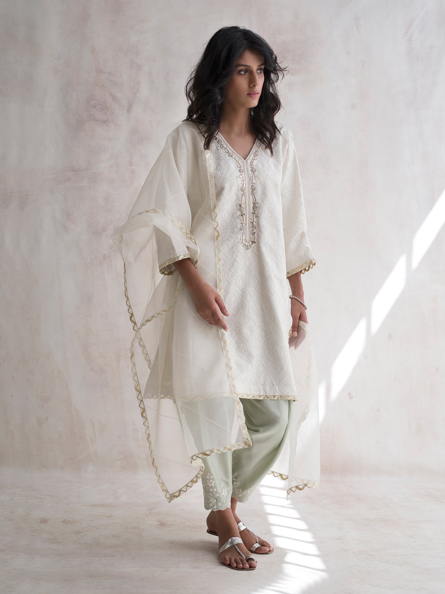 Our effortlessly elegant white shirt is adorned with silk and jeweled embroidery